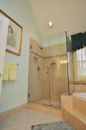 The roomy, glass enclosed shower also picks up the decorative tile element to unify this entire bathroom 