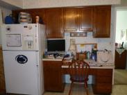 This office area cluttered the kitchen and the bathroom style lighting under the cabinets was not a match to the owner's style